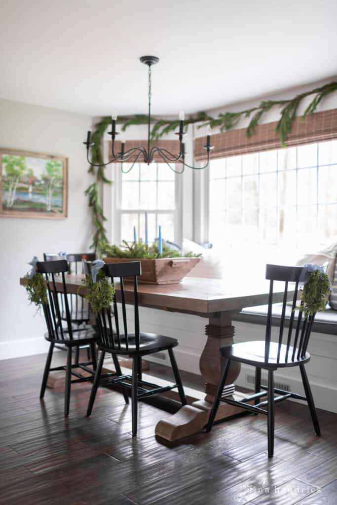 Breakfast nook with black chairs and hints of blue Christmas decorations