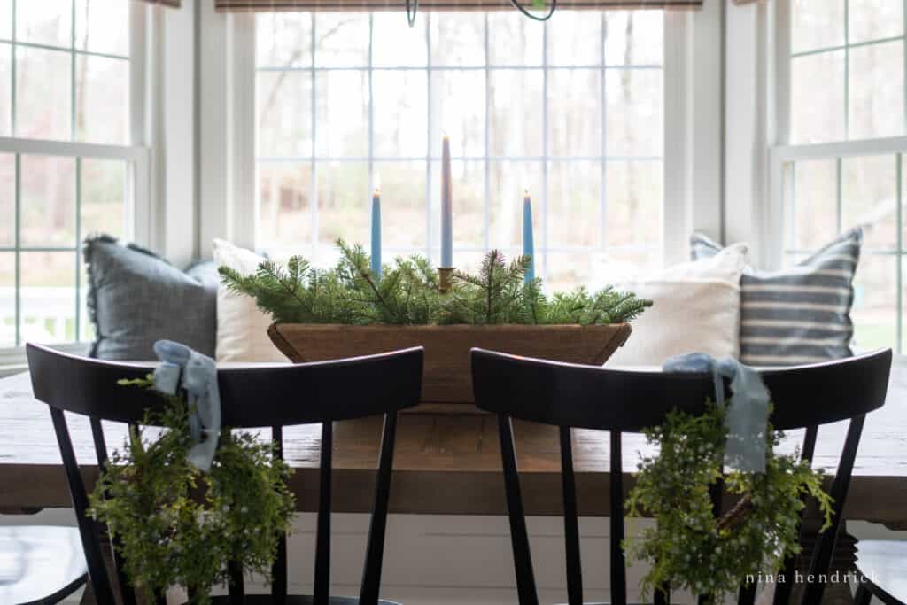 Blue candle arrangements and wreaths on chairs