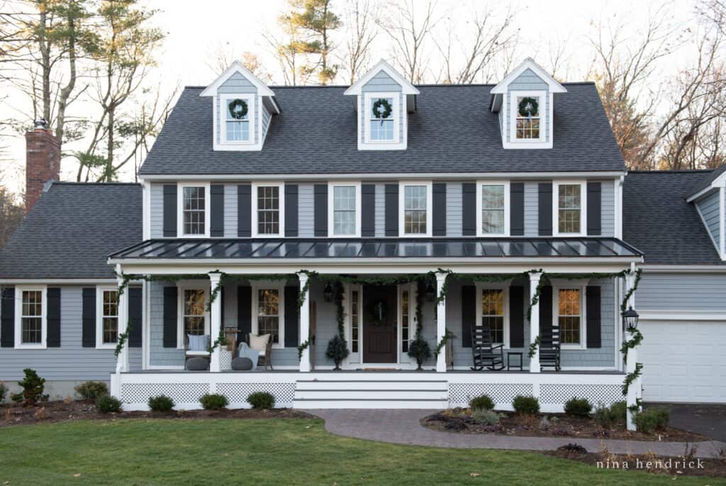 Blue colonial house with subtle blue Christmas decorations and garland