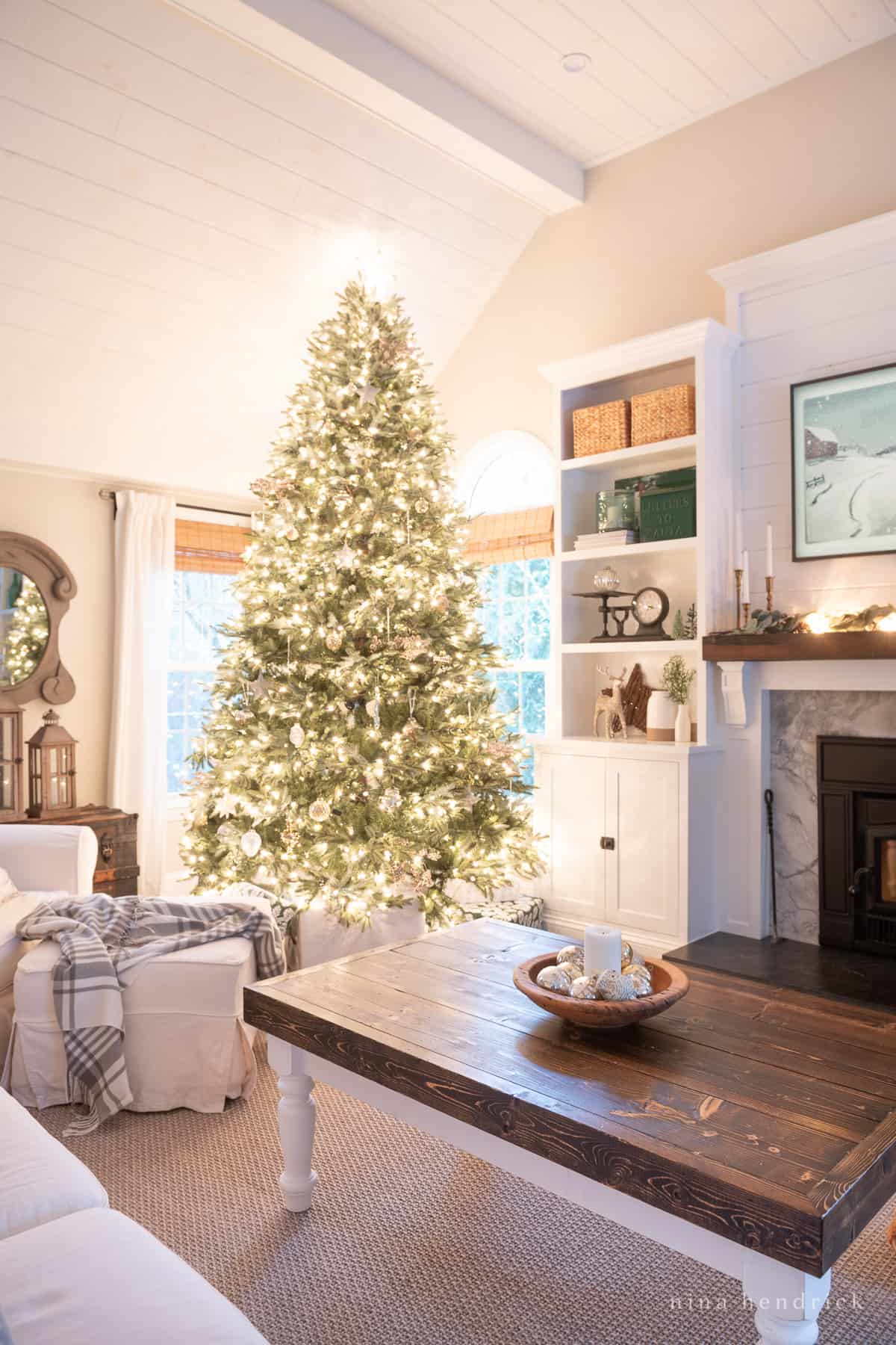 Simple Christmas decor ideas in a family room with a pared down tree and glass ornaments in a bowl