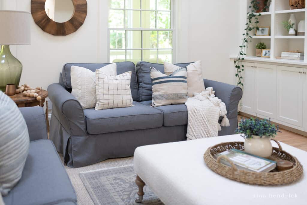 Charcoal gray couch in a white living room with bookcases