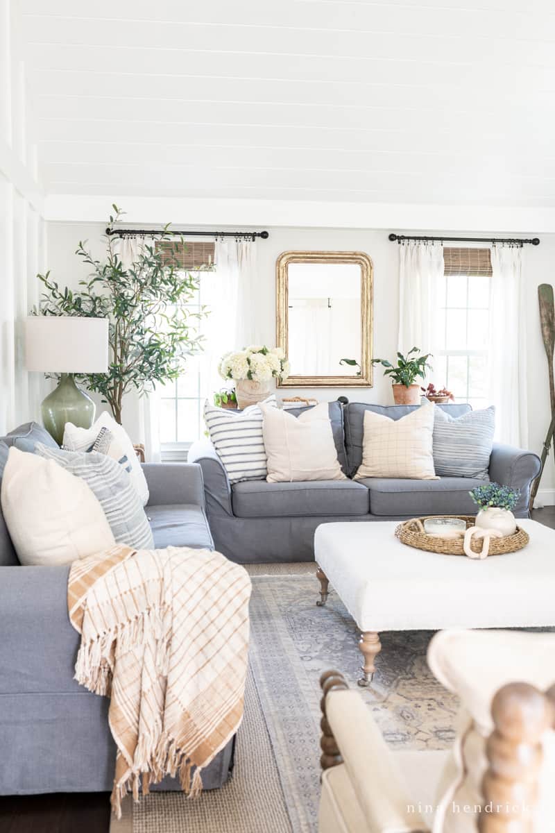 Neutral family room with gray furniture and throw pillows and blankets