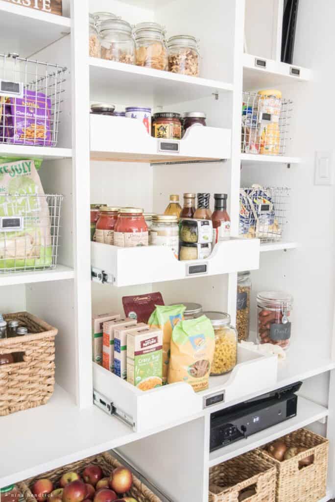 Pull out drawer shelves in an organized white pantry