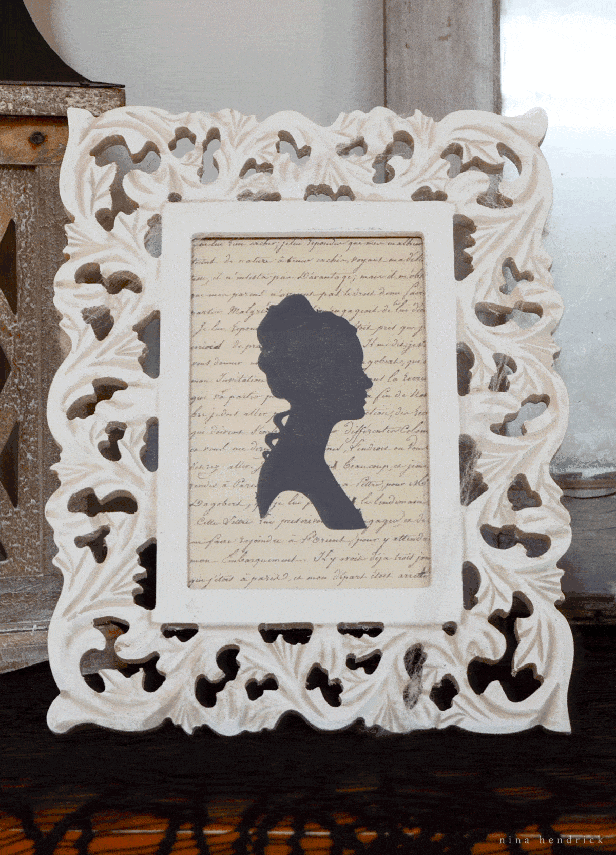 A white frame with a silhouette of a woman, perfect for Halloween decorating ideas.