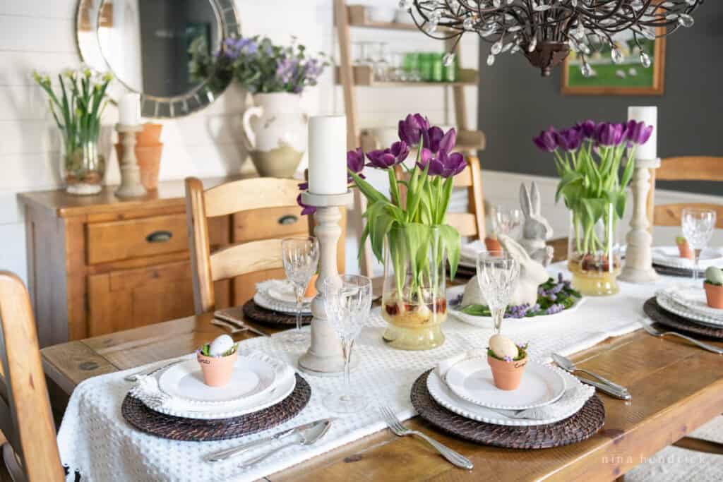 purple easter tablescape with bunny statues and flowerpot