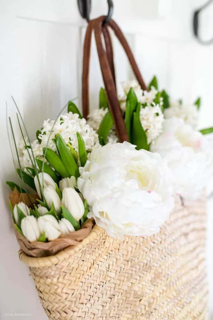 Spring Mudroom Decor | This market basket is filled with fresh flowers and hung in a beadboard mudroom for Spring. 