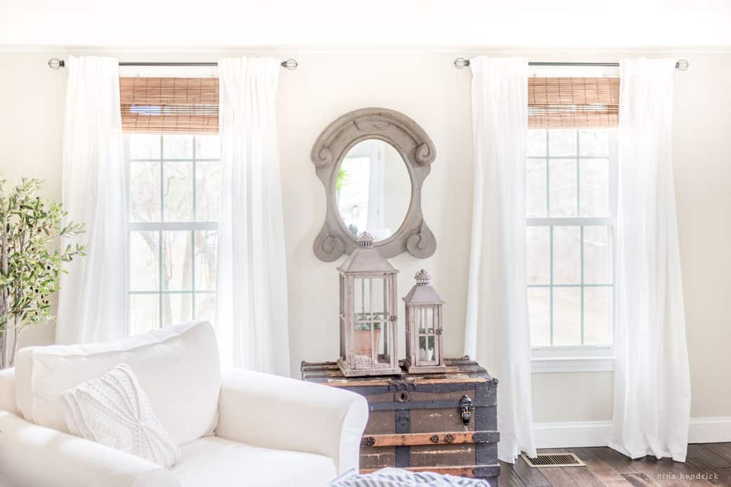 neutral colored living space with white curtains as focal point of the room