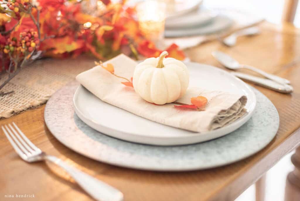 A table setting with a pumpkin on it.