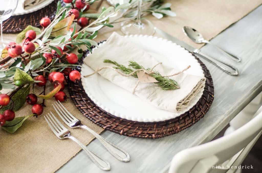 A table setting with berries and greenery.