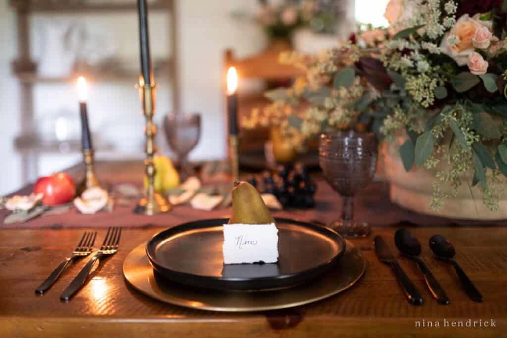 A black plate with a pear on it.