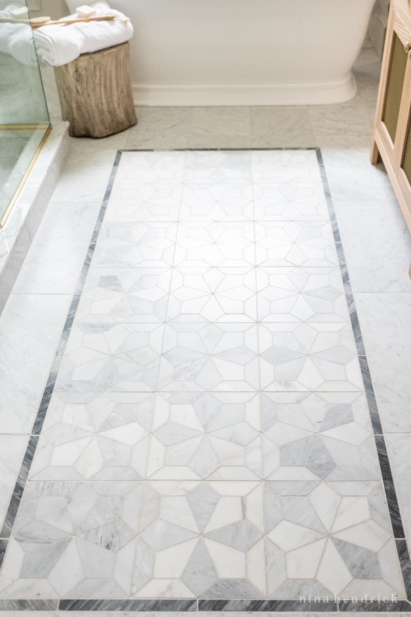 Marble floor tile rug inlay in a bathroom remodel