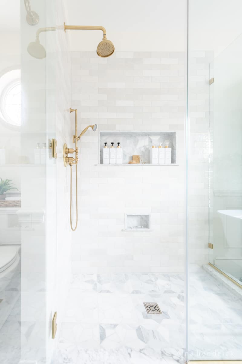 Walk-in shower with marble mosaic floor tile and zellige wall tile in a bathroom makeover