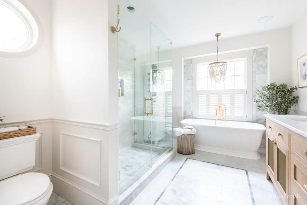 Showing a remodeled bathroom layout with a toilet nook and walk-in glass shower plus a freestanding tub and vanity
