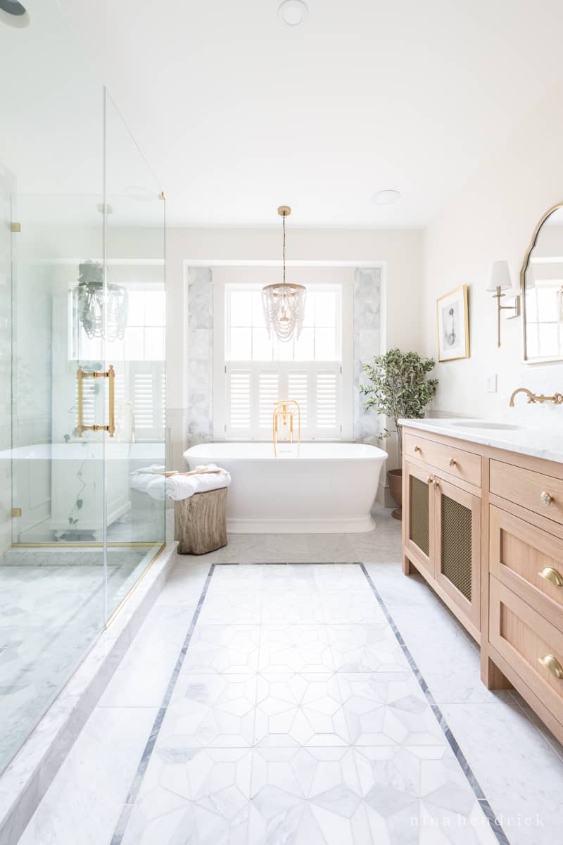 Bathroom remodel featuring mosaic tile with a contrasting border and brass accents