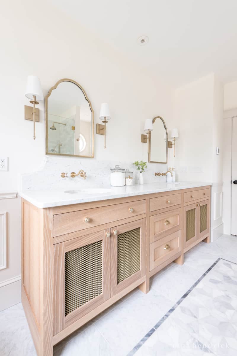 White oak bathroom vanity with marble countertop and scalloped backsplash design