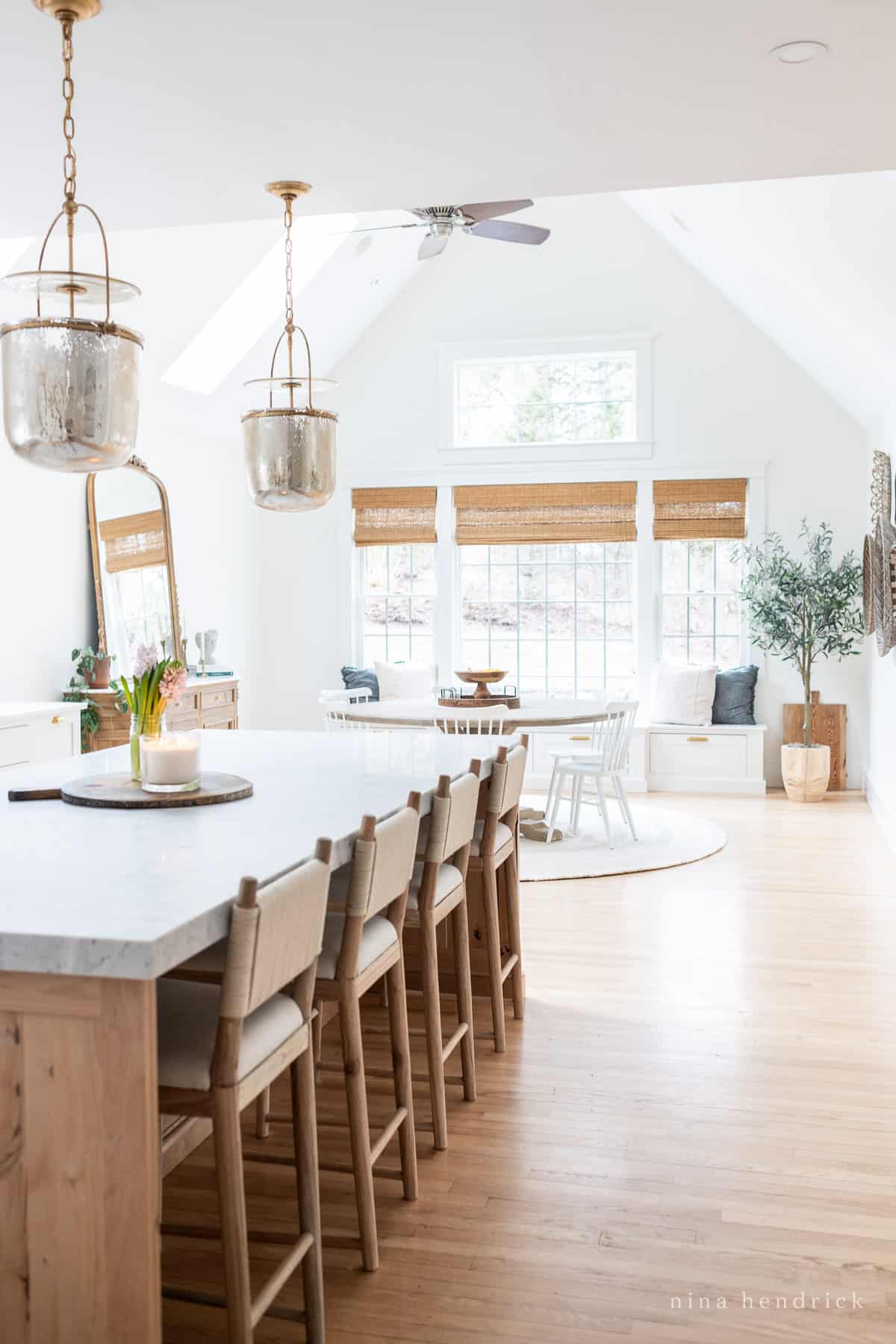 Kitchen island with stools and breakfast nook with timeless finishes