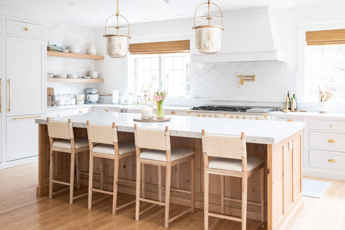 Timeless kitchen remodel with wood island and bar stools with mercury-style glass pendants