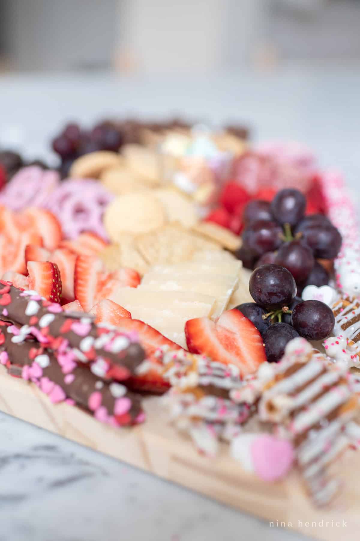 Close-up of fruit and cheese with chocolate-covered pretzels