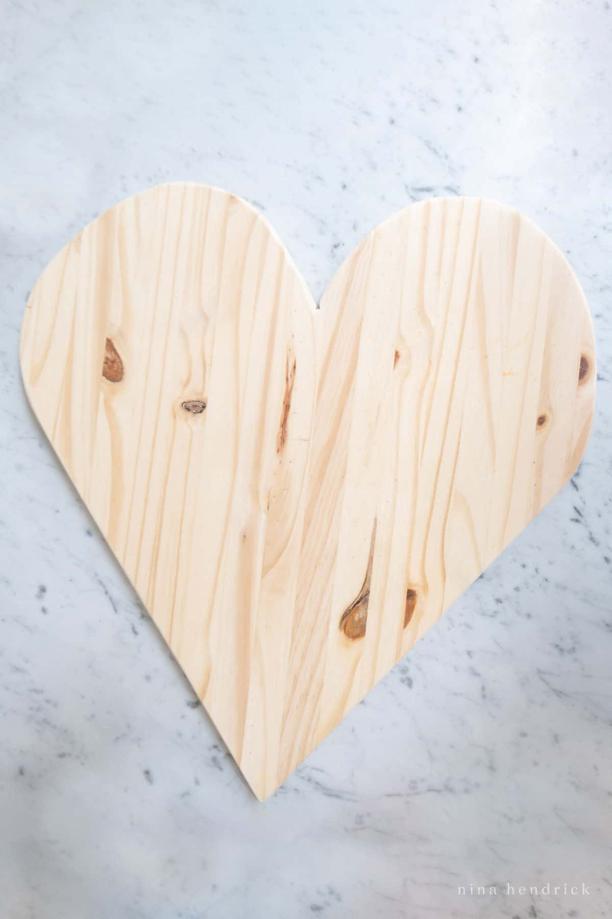 Heart-shaped wooden board on a marble background