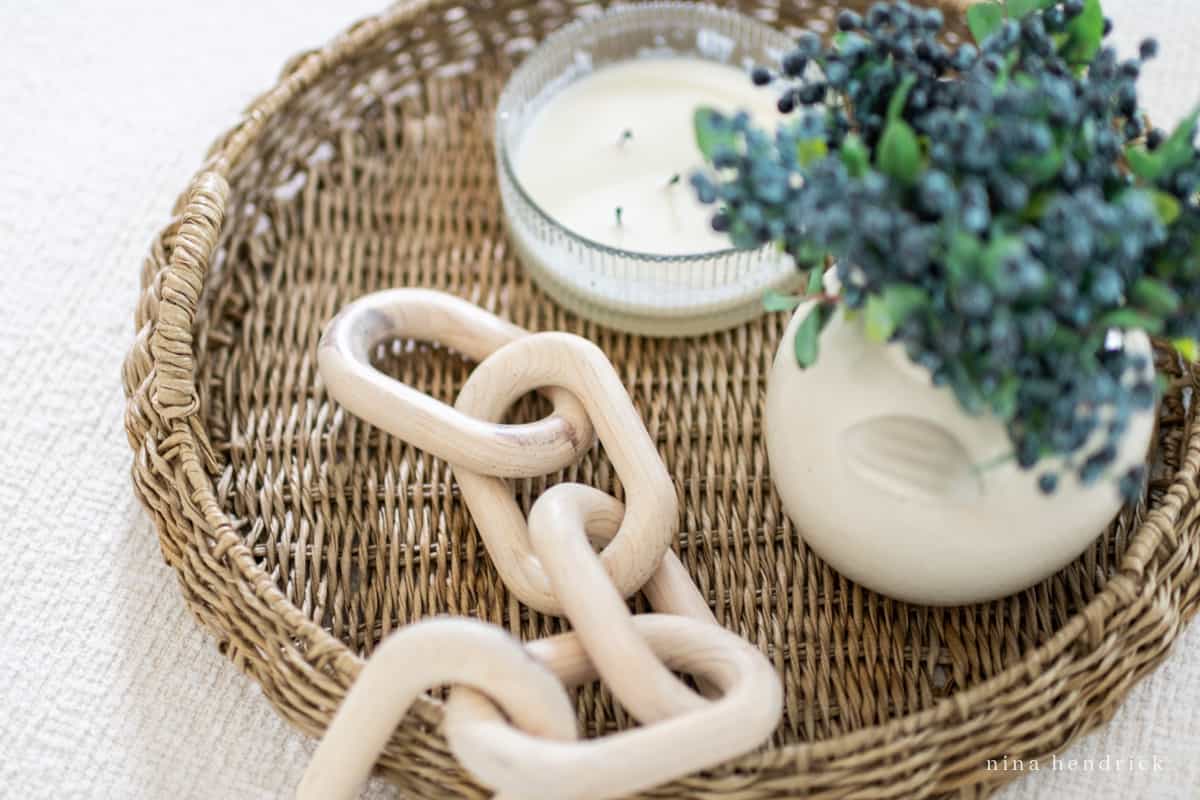 Vignette with wooden chain decor object, a vase, and a candle