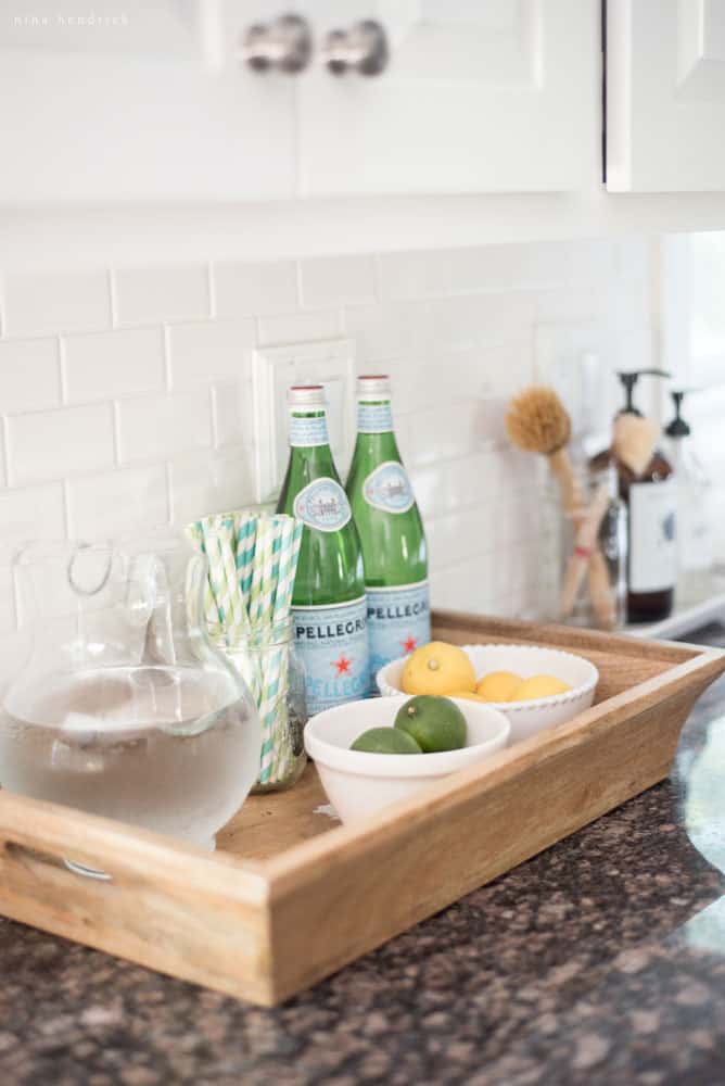 Kitchen countertop vignette with sparkling water, lemons, limes, and straws