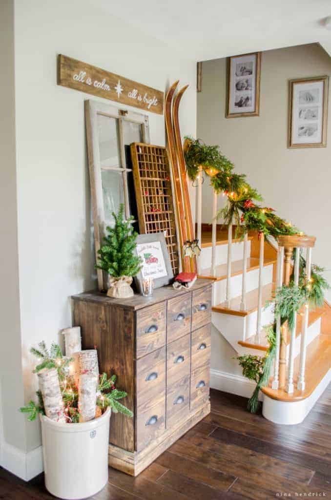Rustic and cozy Christmas vignette with a wooden apothecary cabinet and a printable tree farm sign.