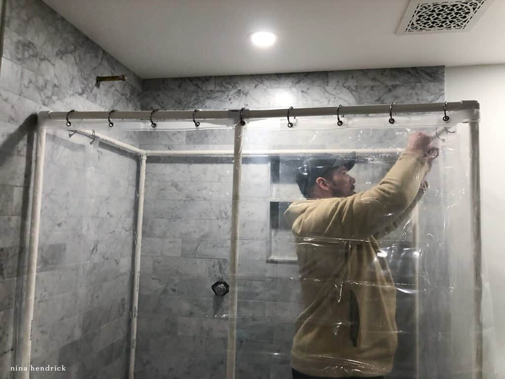 Man creating a PVC DIY Shower enclosure when bathroom improvement projects don't go according to plan.