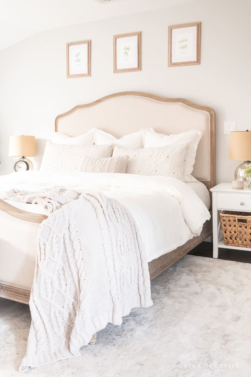 Cozy winter bedroom decor after Christmas with a soft knit blanket and a bunch of pillows and throws.