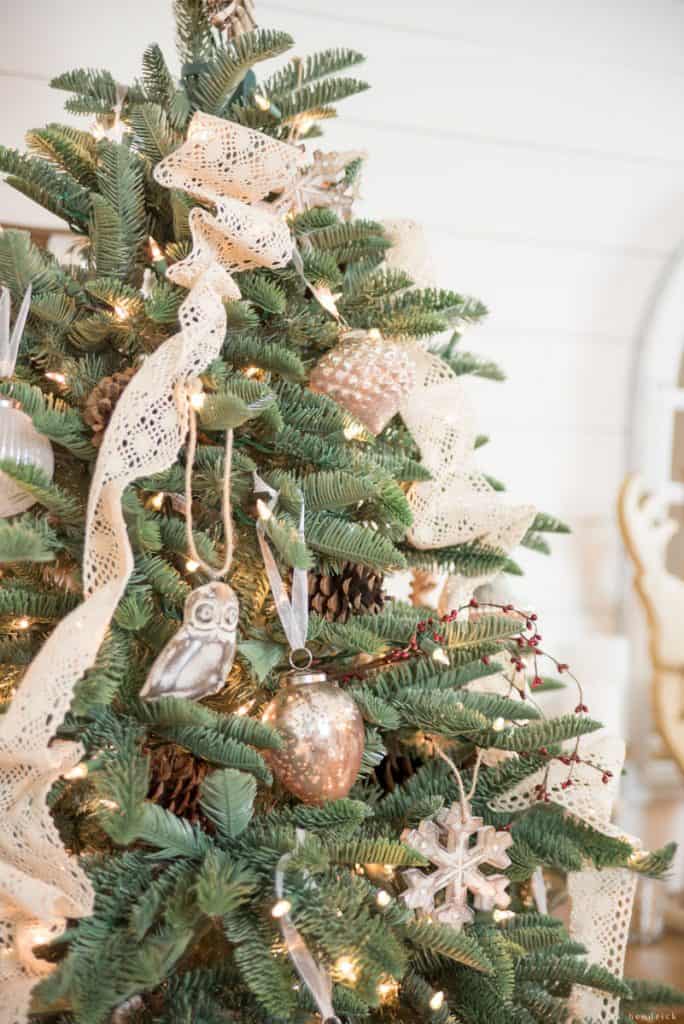 Berries and lace decor with wooden ornaments on a holiday tree