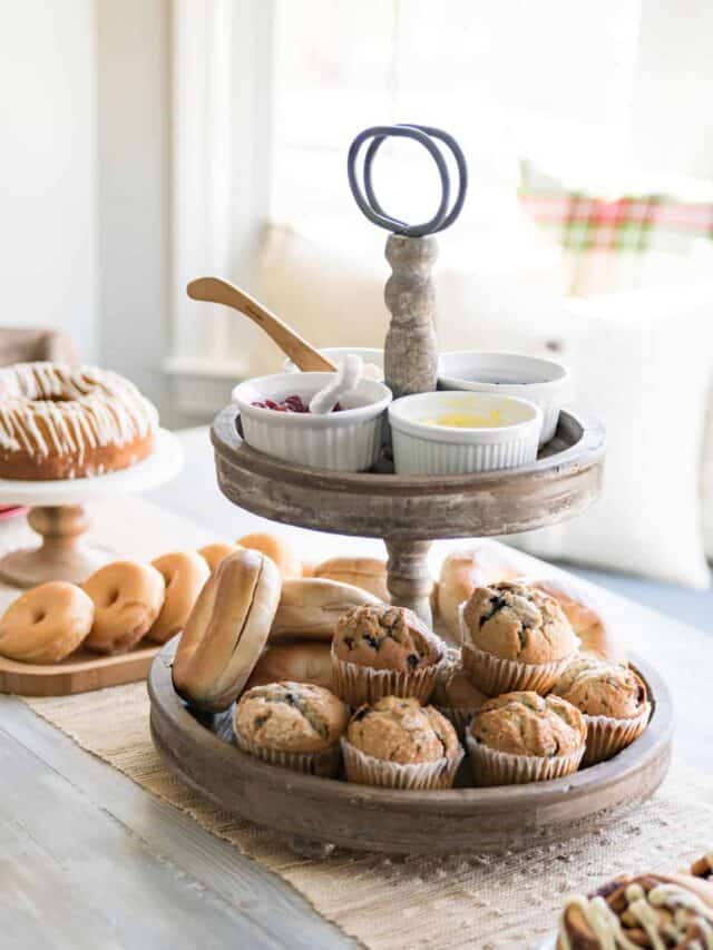 Two tier tray with muffins and bread on a table.