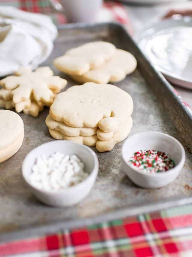 Christmas cookies on a baking sheet with sprinkles.