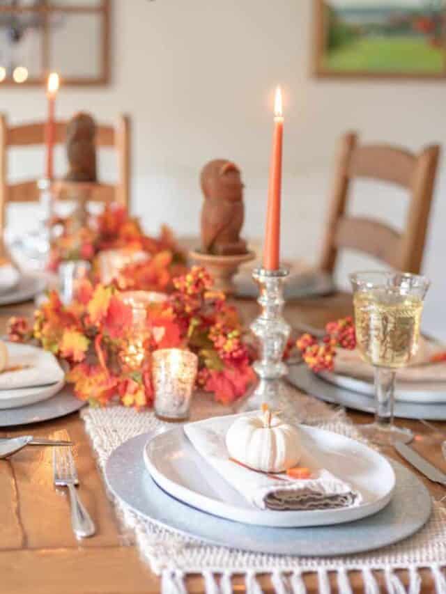 Thanksgiving table setting with candles and pumpkins.