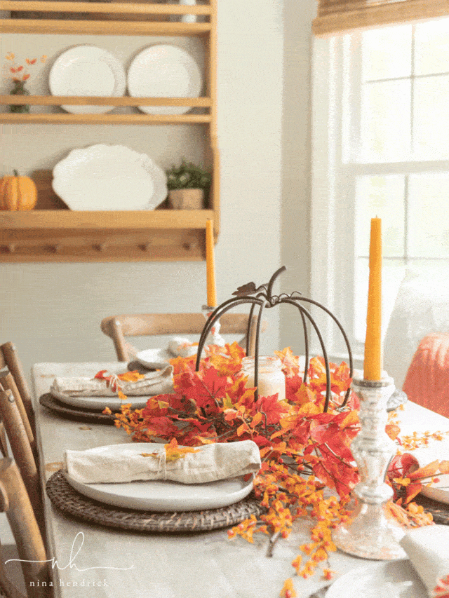 A dining room table with a fall table setting.