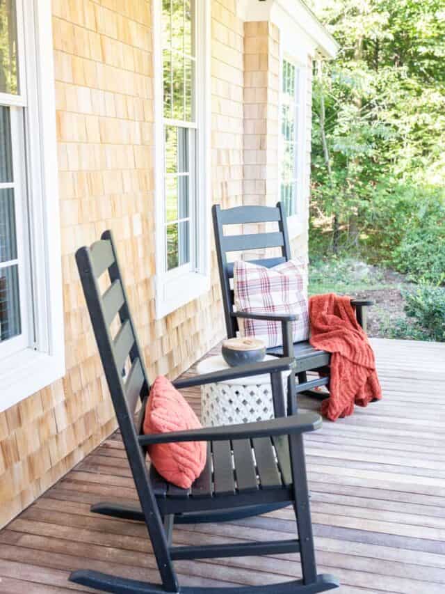 Two black rocking chairs on a porch.