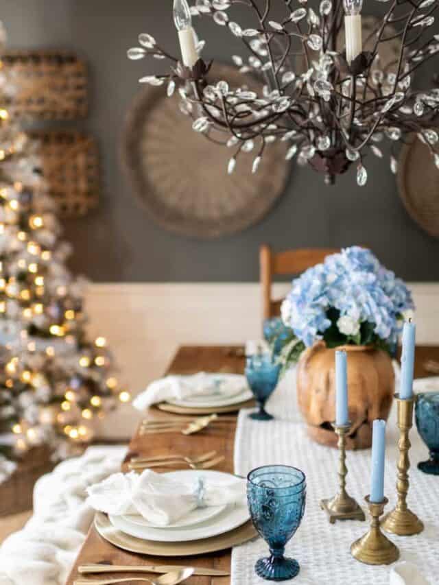 A blue and white christmas table setting with a christmas tree.